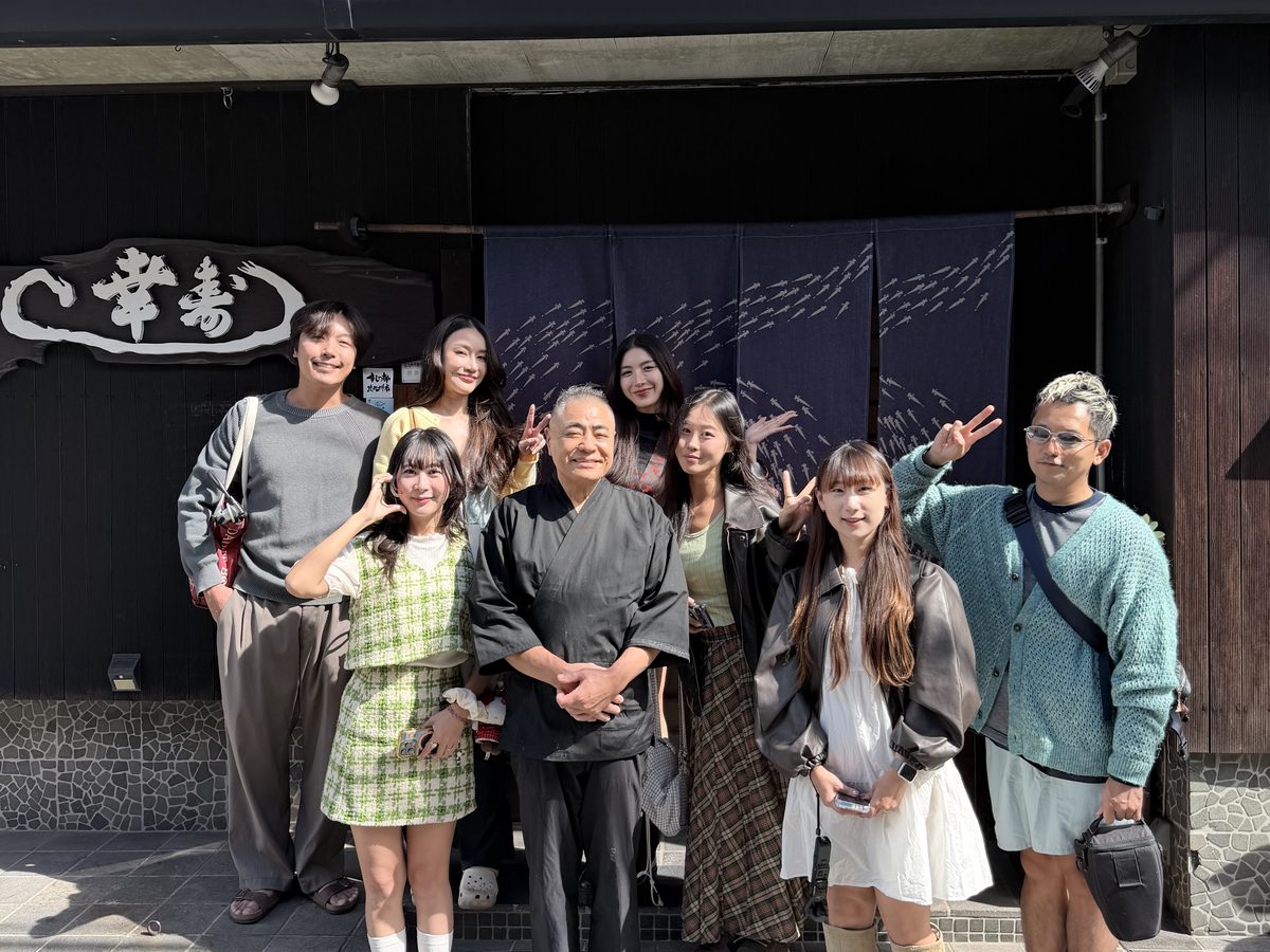 お寿司屋さんの店先で大将を囲むクリエイターの皆さん