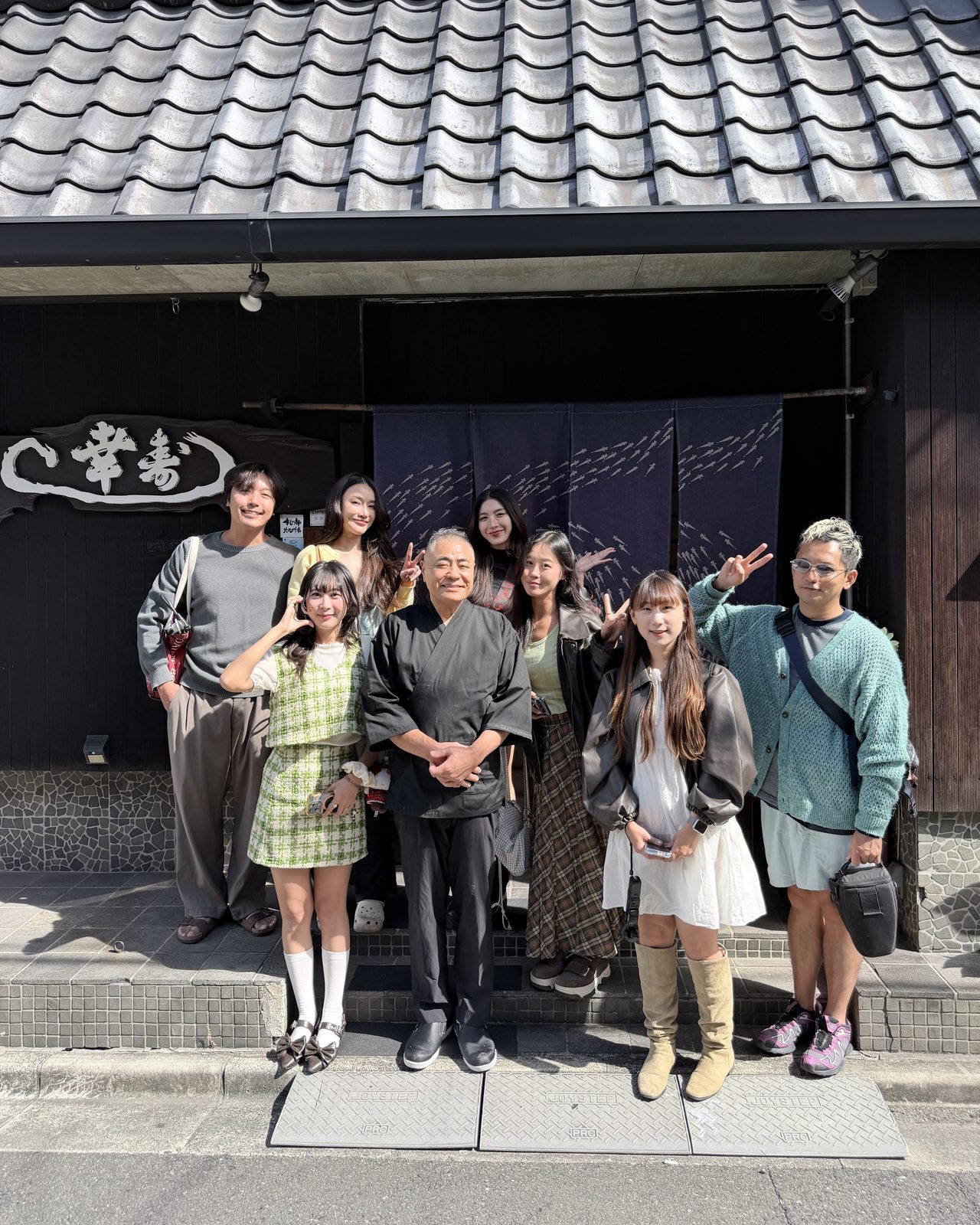 お寿司屋さんの店先で、大将を囲んでクリエイターの皆さんと記念撮影