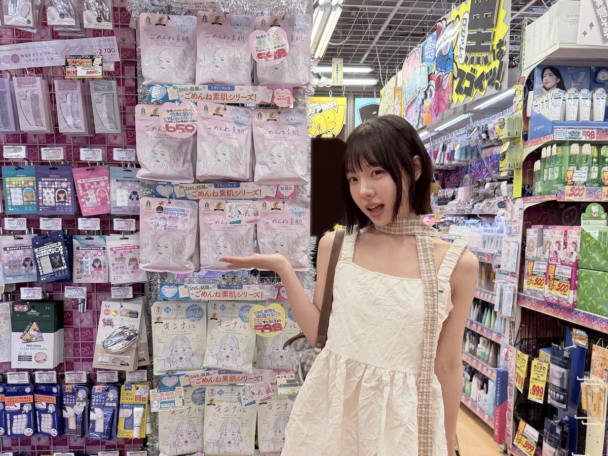 コスメ売り場の棚の前でポーズをとるクリエイター