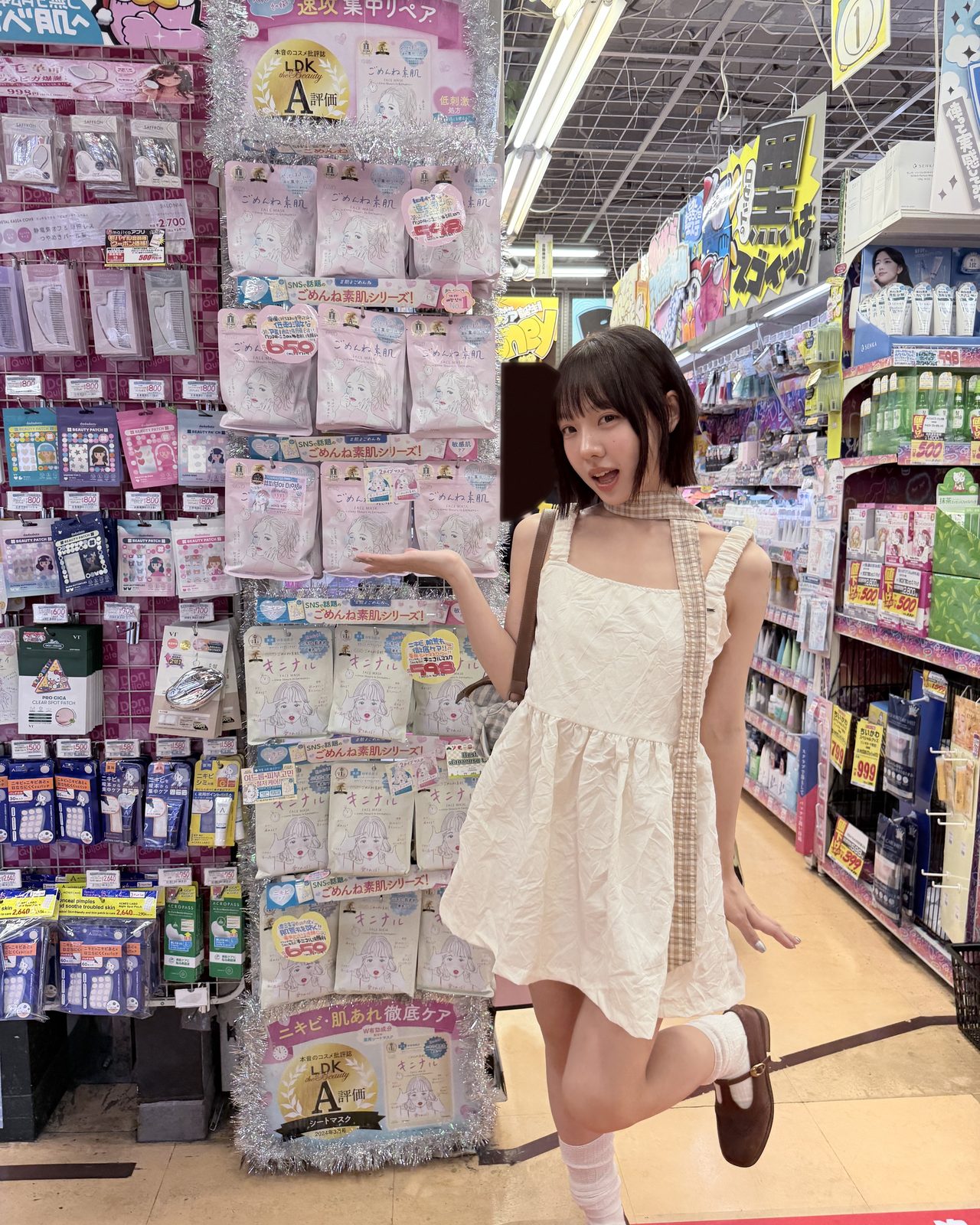 ディスカウントストアのコスメ売り場で、商品棚の前でポーズをとるクリエイター