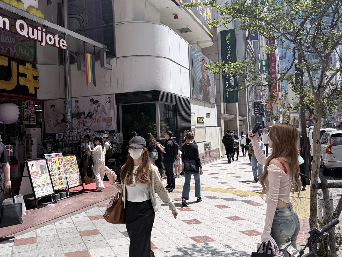新宿の店先で外観を撮影するクリエイターの後ろ姿